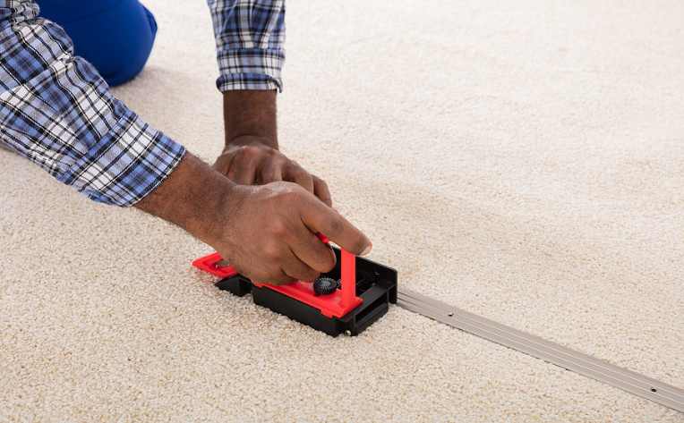 man installing new carpet using seam fitter